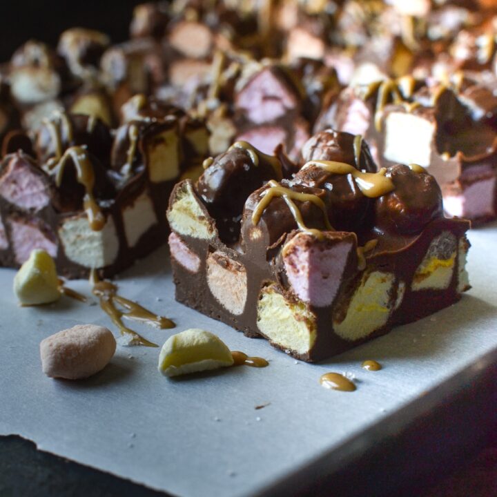 A close up of a chocolate peanut butter square filled with coloured mini marshmallows