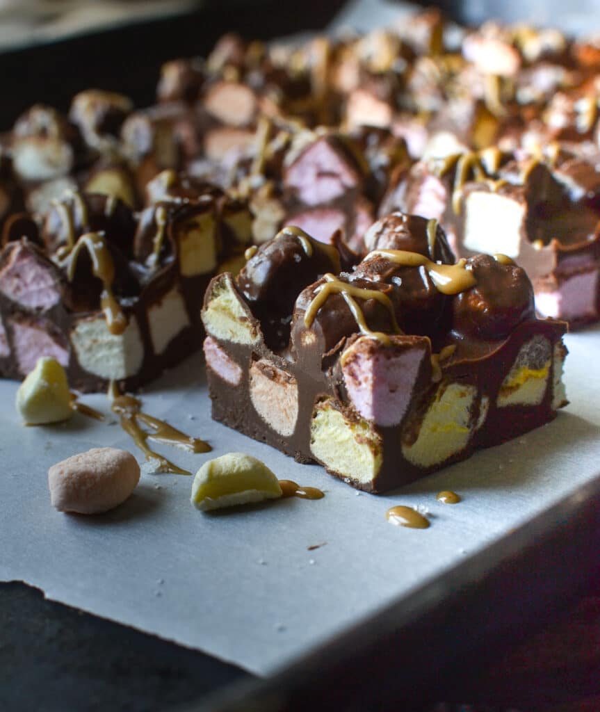 A close up of a chocolate peanut butter square filled with coloured mini marshmallows