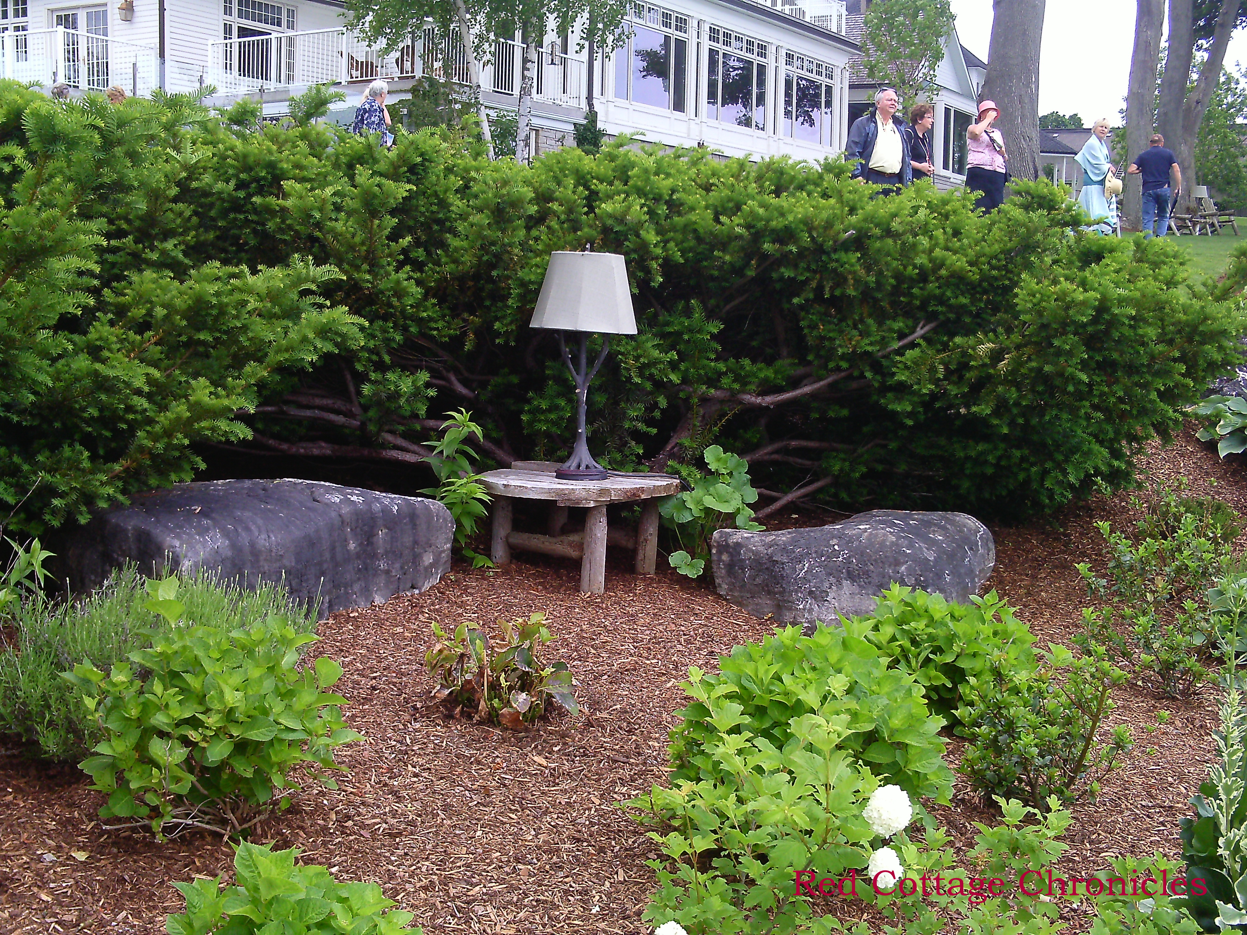 outdoor twig lamp and stone seats in a garden near lake Ontario