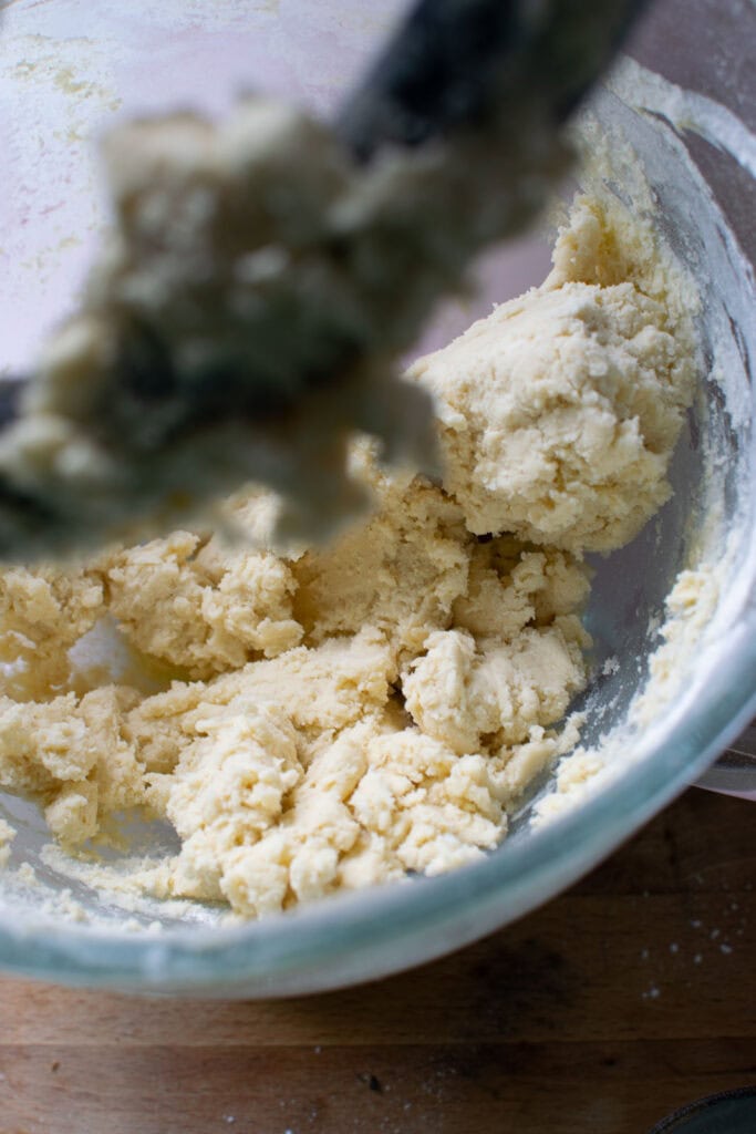 Butter and flour mixture beat together in the bowl of electric mixer.