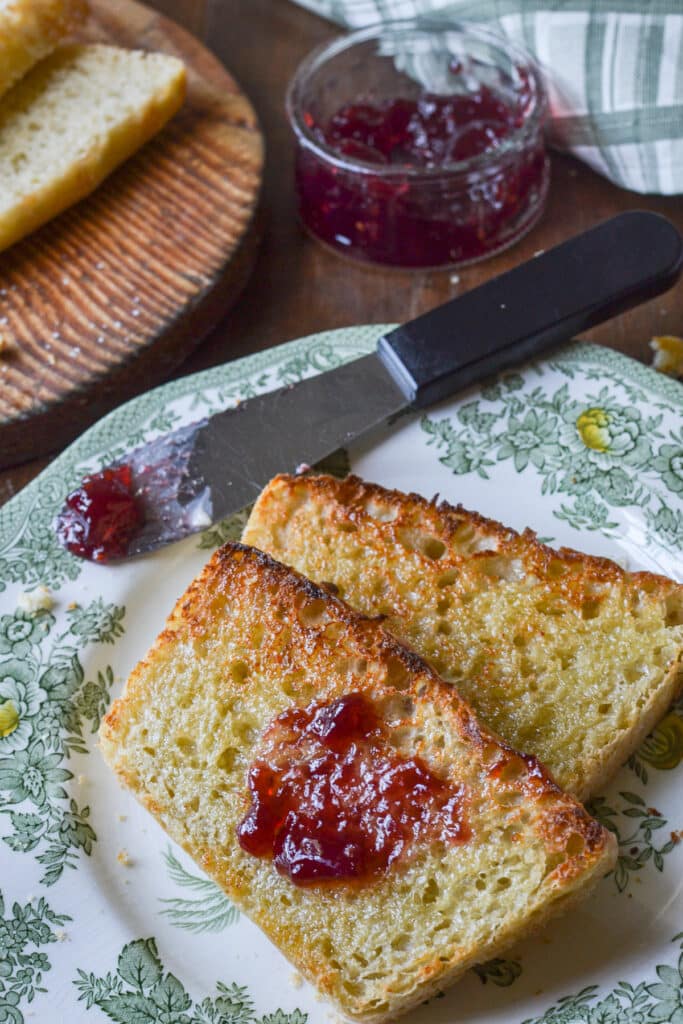 2 slices of toasted English muffin loaf on a green transfer ware plate