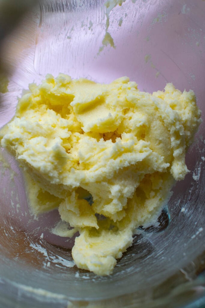 Butter, sugar and lemon mixture in bowl of electric mixer.