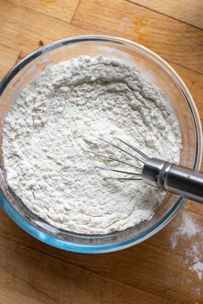 Dry ingredients for cupcakes mixed with a whisk, including flour, baking powder and baking soda.