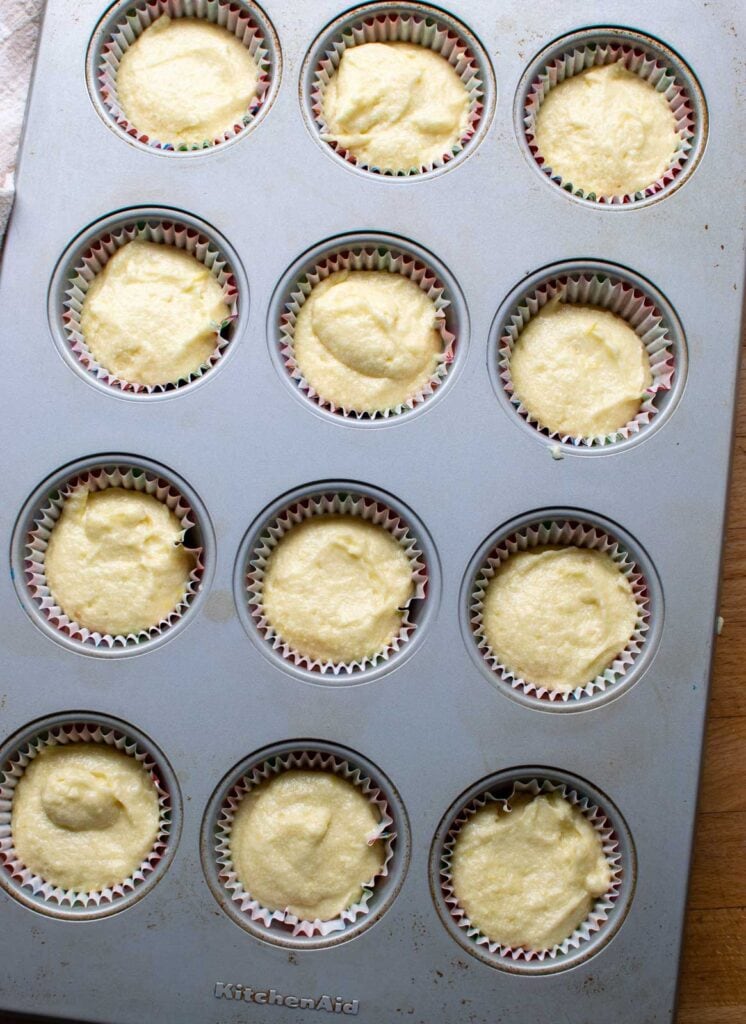 Cupcake batter divided between 12 muffin tins before baking.