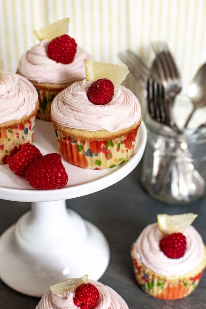 3 Pink Lemonade Cupcakes on a cake stand.
