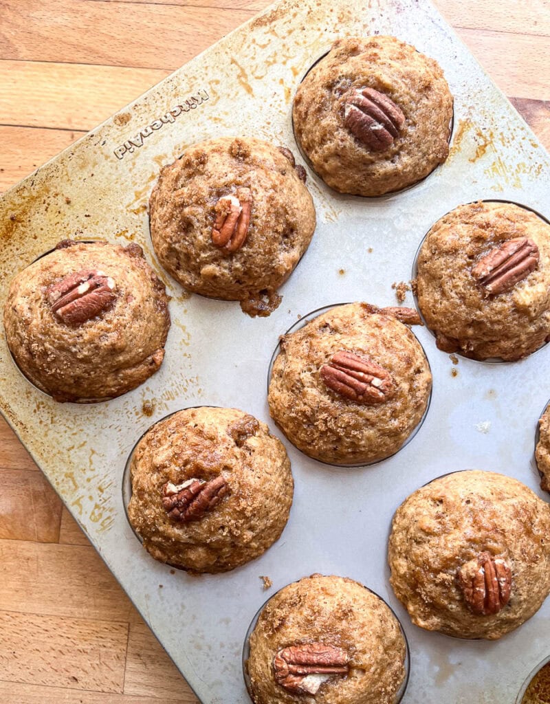 Freshly baked pecan muffins cooling while still in muffin tins.