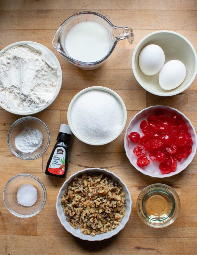 Ingredients to make cherry walnut quick bread including flour, sugar, and maraschino cherries.