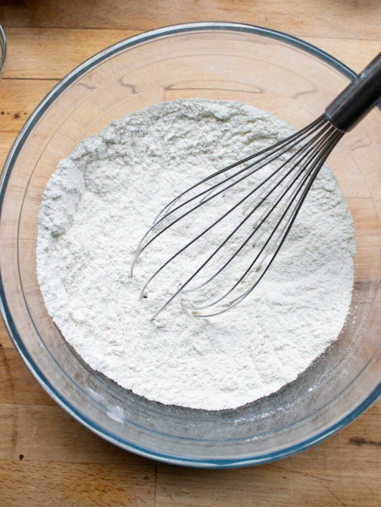 Dry ingredients to make a cherry walnut quick bread in a mixing bowl whisked together with a wire whisk.