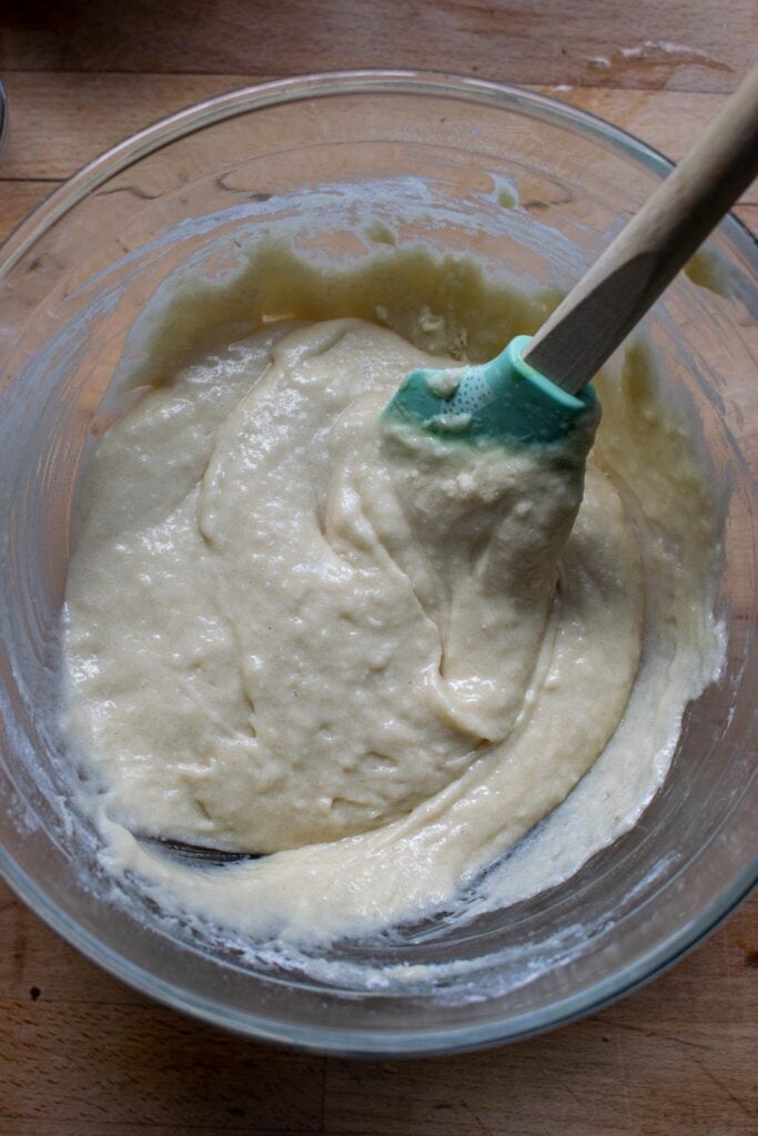Dry and wet ingredients to make cherry walnut bread that have been mixed to create the batter.