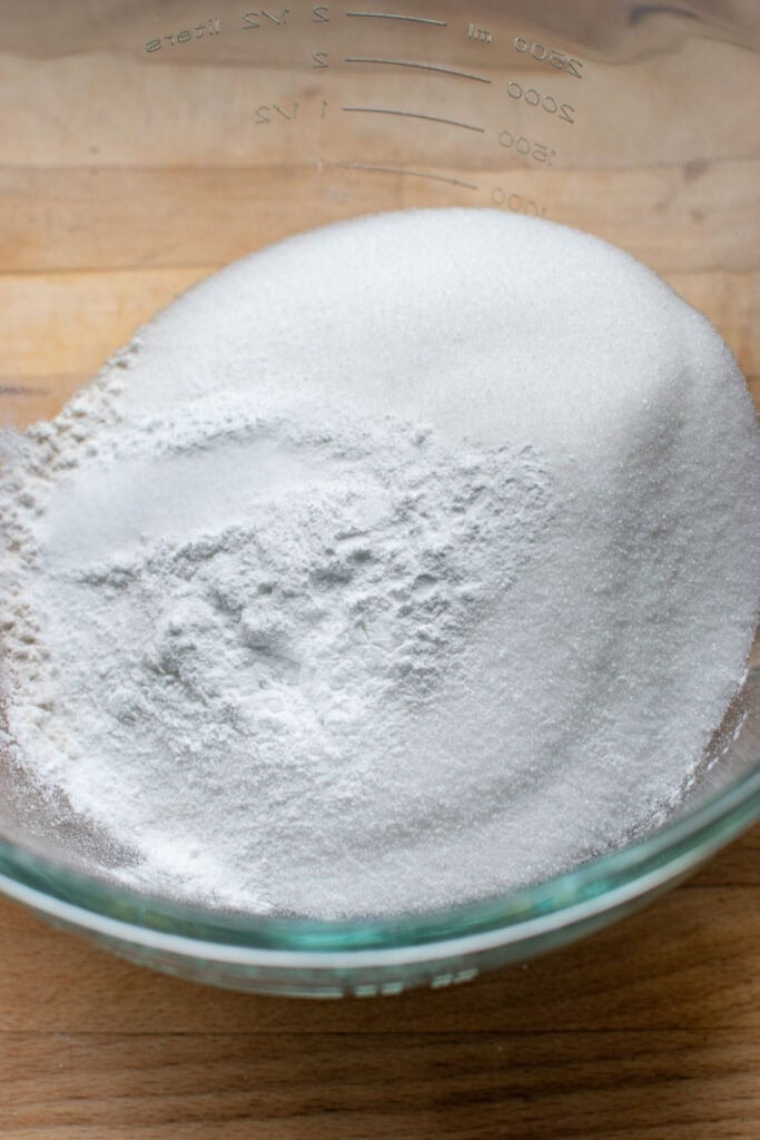 Flour, sugar, salt and baking powder in the bowl for an electric mixer.