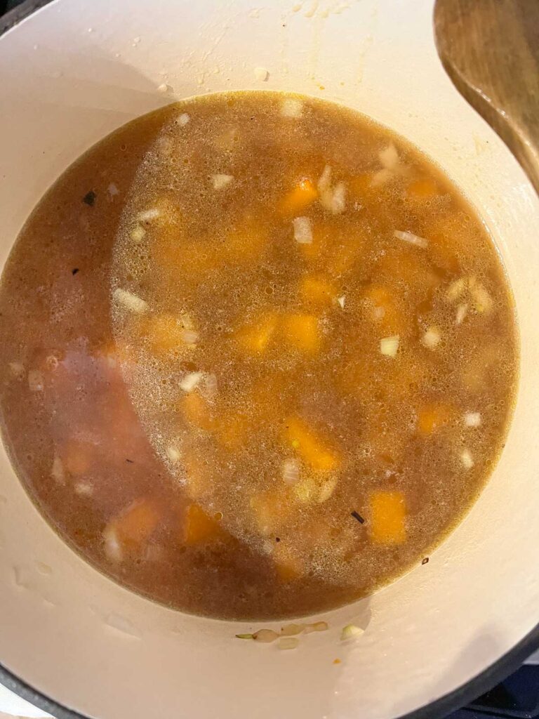 Vegetable broth and roasted squash added to the onions in a stock pot and brought to a boil.
