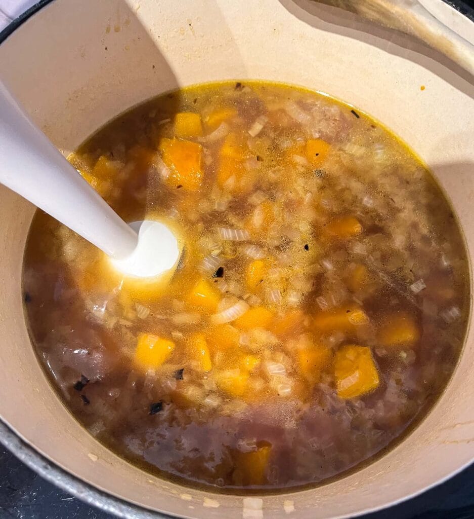 Butternut squash soup in a stock pot before it is pureed with an immersion blender.