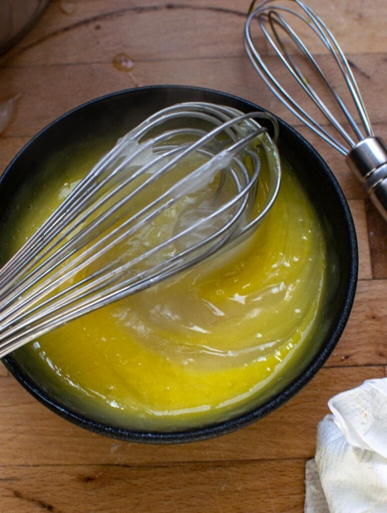 A cup of thickened sugar mixture stirred into beaten egg yolks.