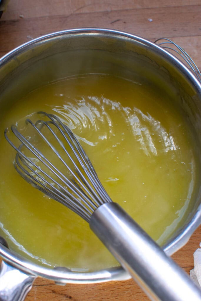 Thickened egg yolks returned to the saucepan with remaining sugar mixture on the stove top.
