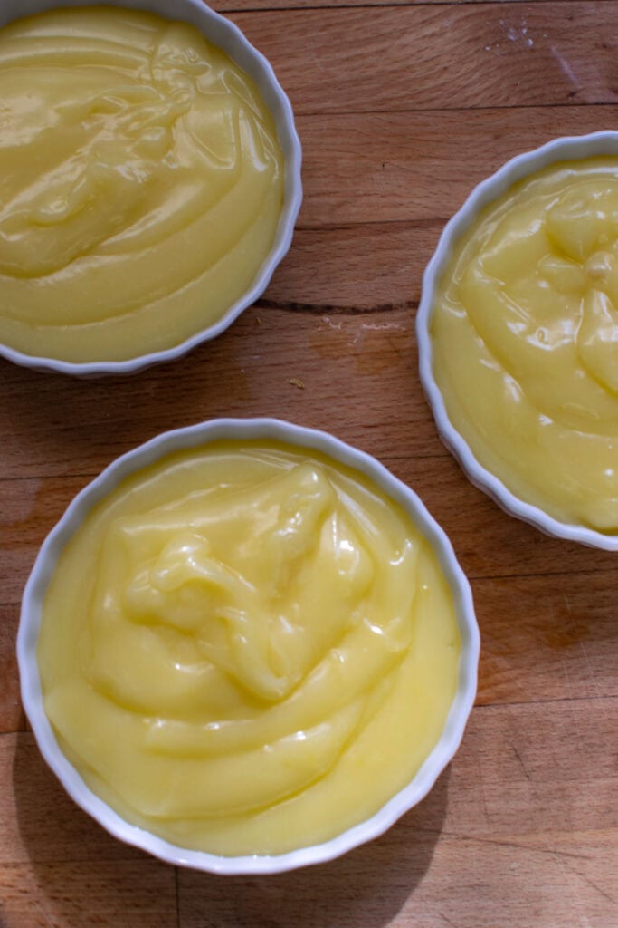 Lemon pie filling spooned into individual shallow ramekins.