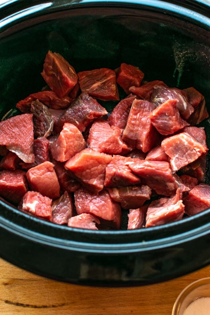 Cubed stewing beef in a slow cooker.