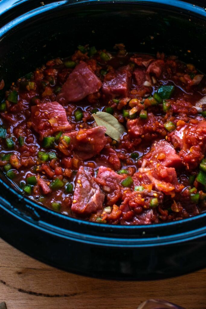 Ingredients for sweet and sour slow cooker steak stirred together in the crockpot.