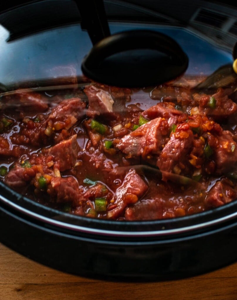 Slow cooker filled with ingredients to make sweet and sour beef at the start of cooking.