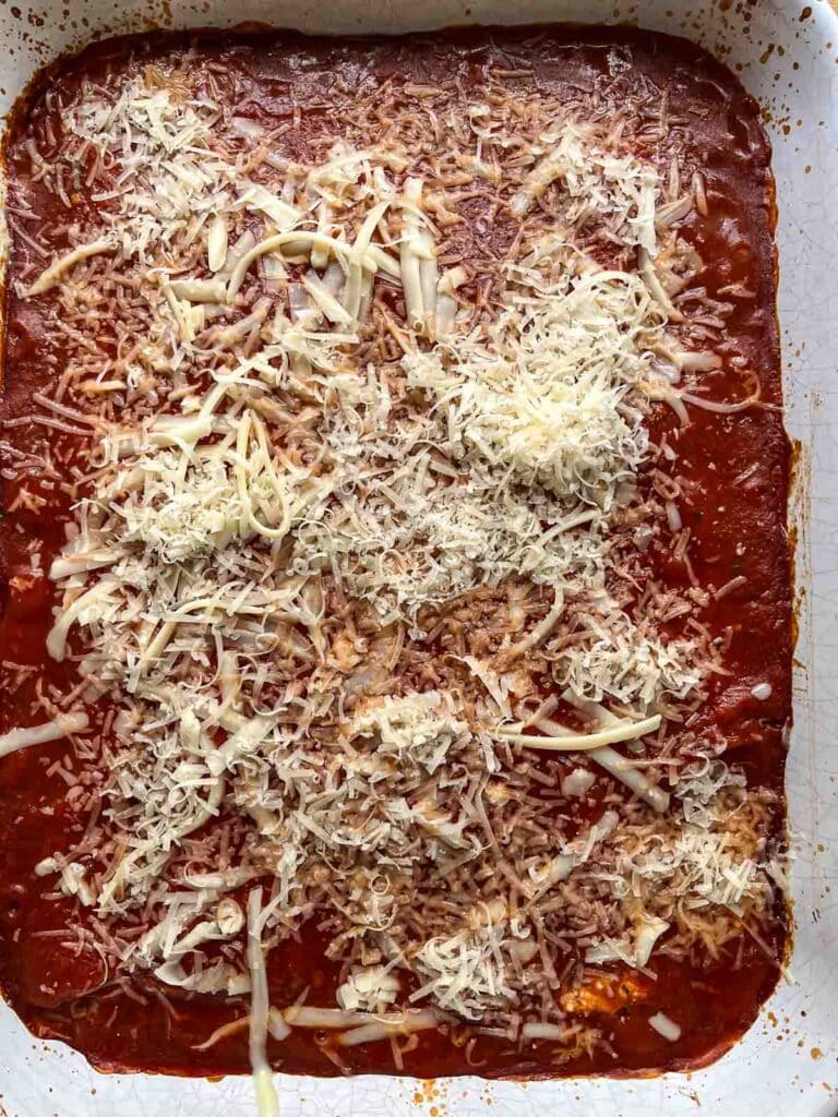 Baking manicotti sprinkled with cheese before melting.