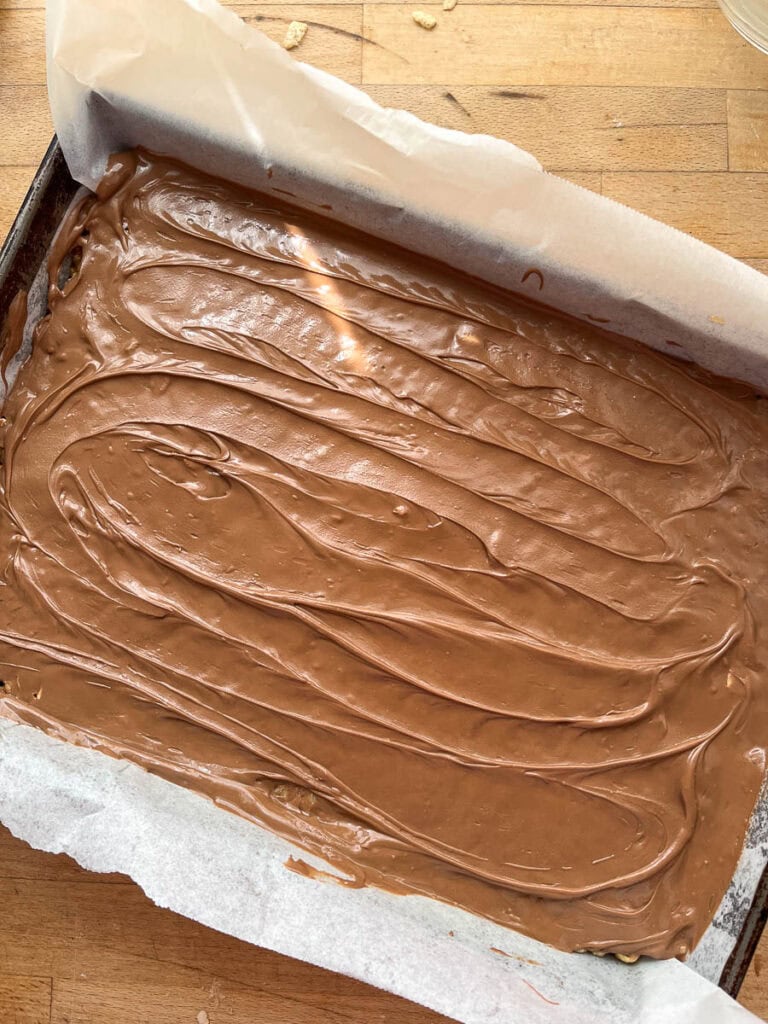 Melted chocolate topping spread over sweet Marie bar base.