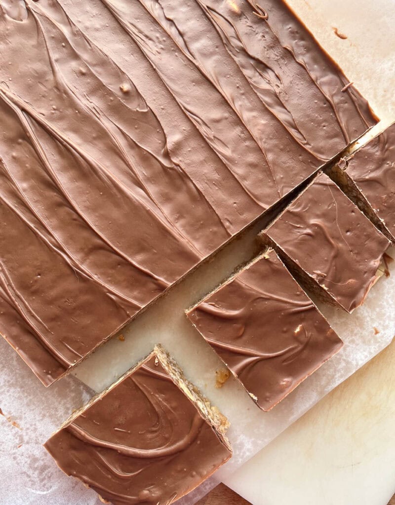 Sweet Marie Bars on a piece of parchment paper with 3 pieces cut.