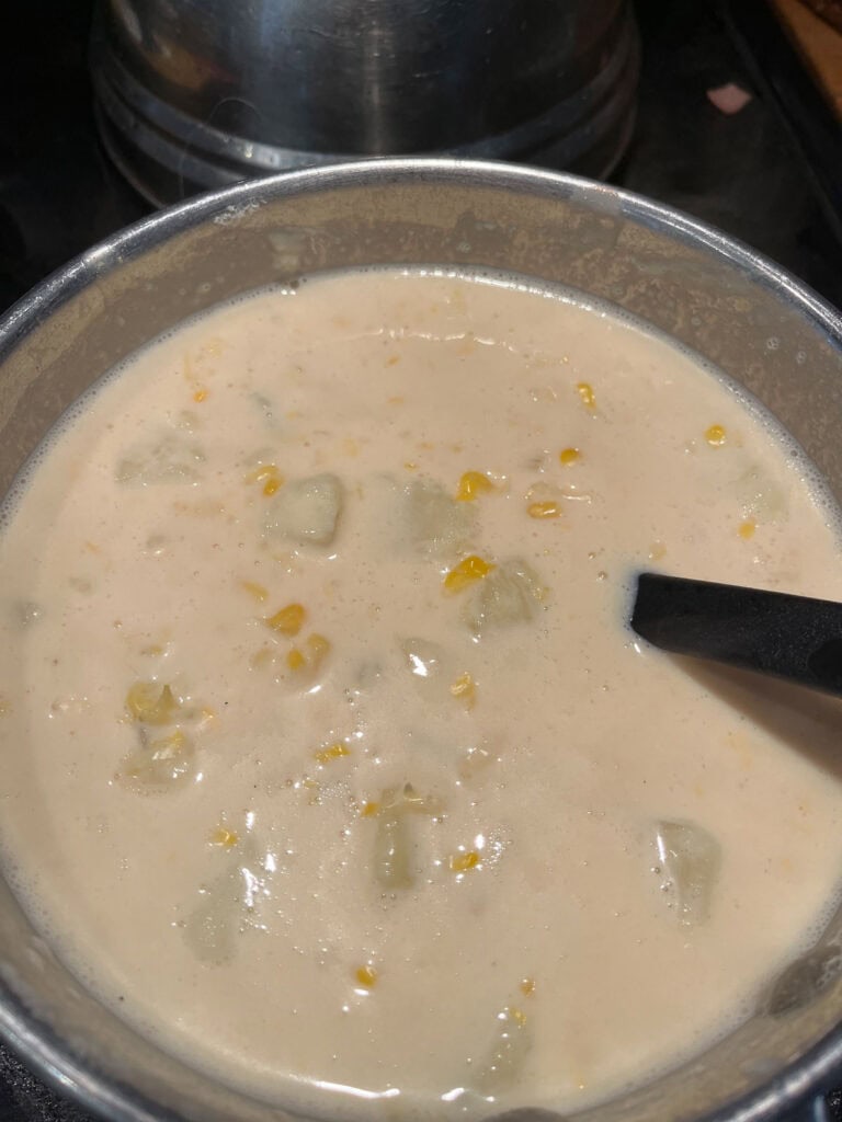 Potato Bacon Soup in a pot, simmering on low temperature.