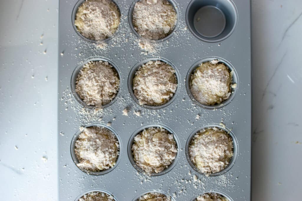 Greek yogurt banana muffins with a streusel topping ready to go into the oven.