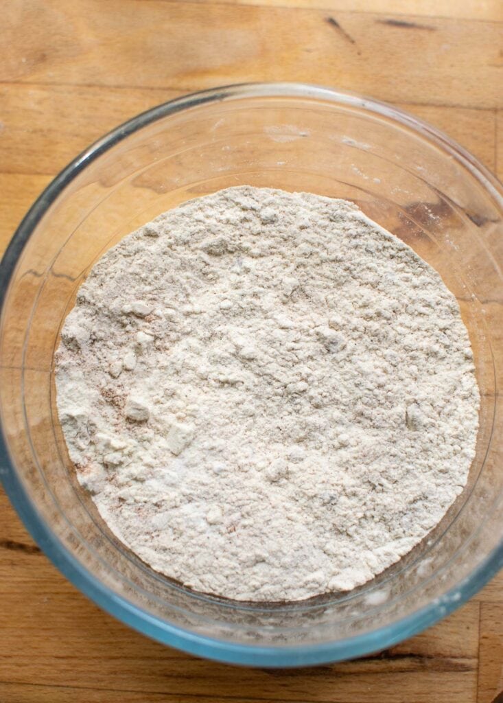 Dry ingredients to make muffins stirred together in a glass mixing bowl.