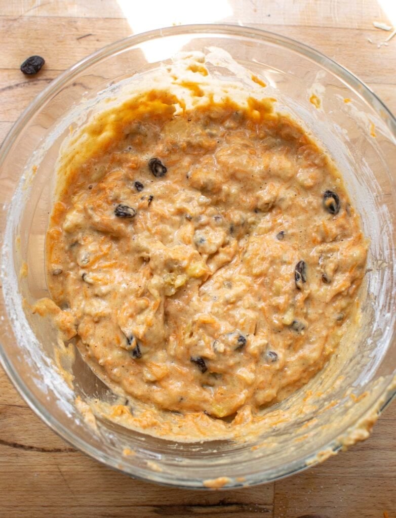 Batter for morning glory muffins in a glass mixing bowl.