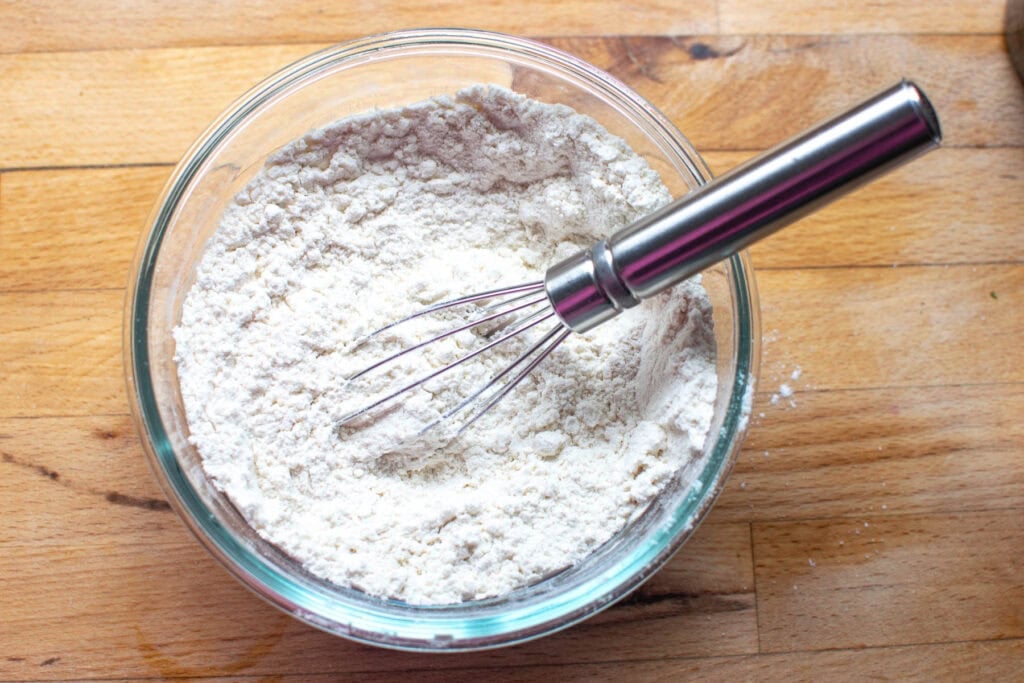 Dry ingredients to make banana cherry chocolate chip muffins whisked together in a glass measure bowl.