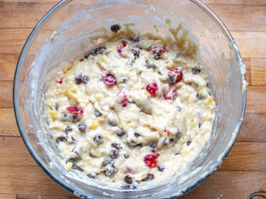 Chocolate chips and cherries folded into banana muffin batter to make cherry chocolate chip muffins.