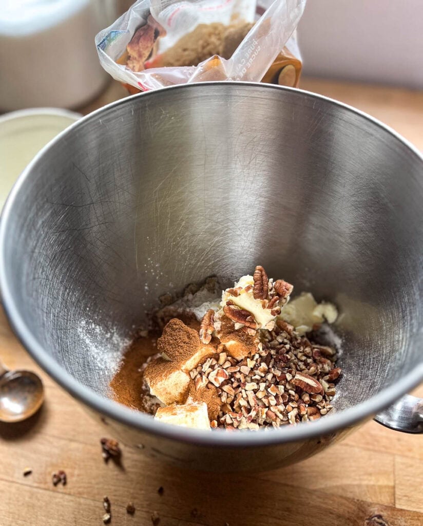 Brown sugar, butter and chopped pecans in a bowl for electric mixer.