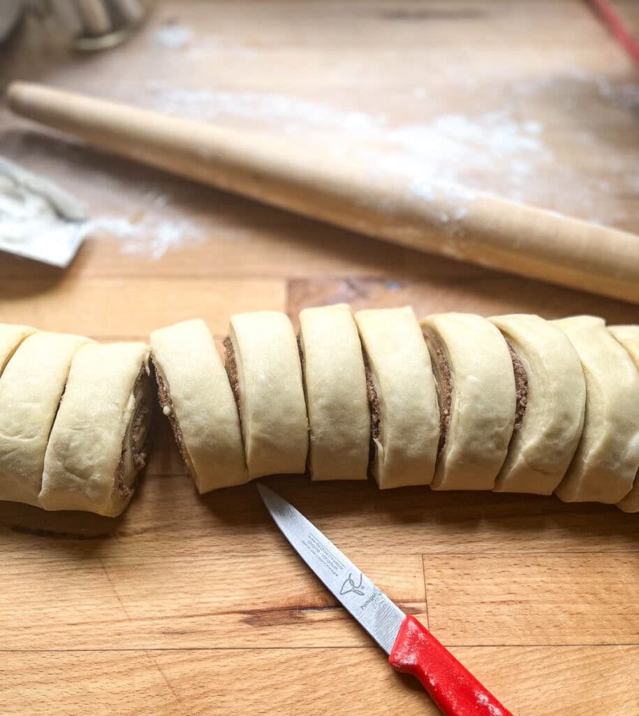 Cinnamon rolls that have just been cut into 1 inch slices before baking.