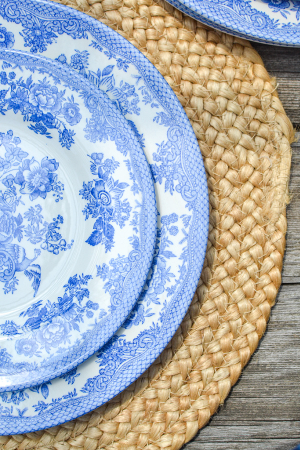 Blue and white dishes on a round rattan placement