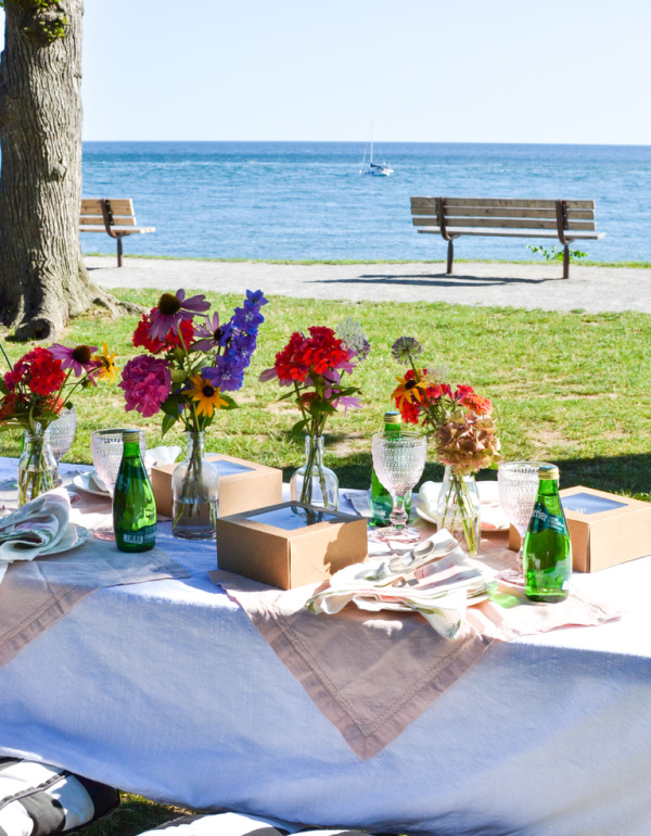 Sailboat passes a pretty picnic table near the lake