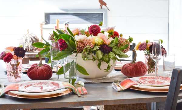 pink and gold table setting for autumn with a dahlia centrepiece and muted pink transfer ware plates