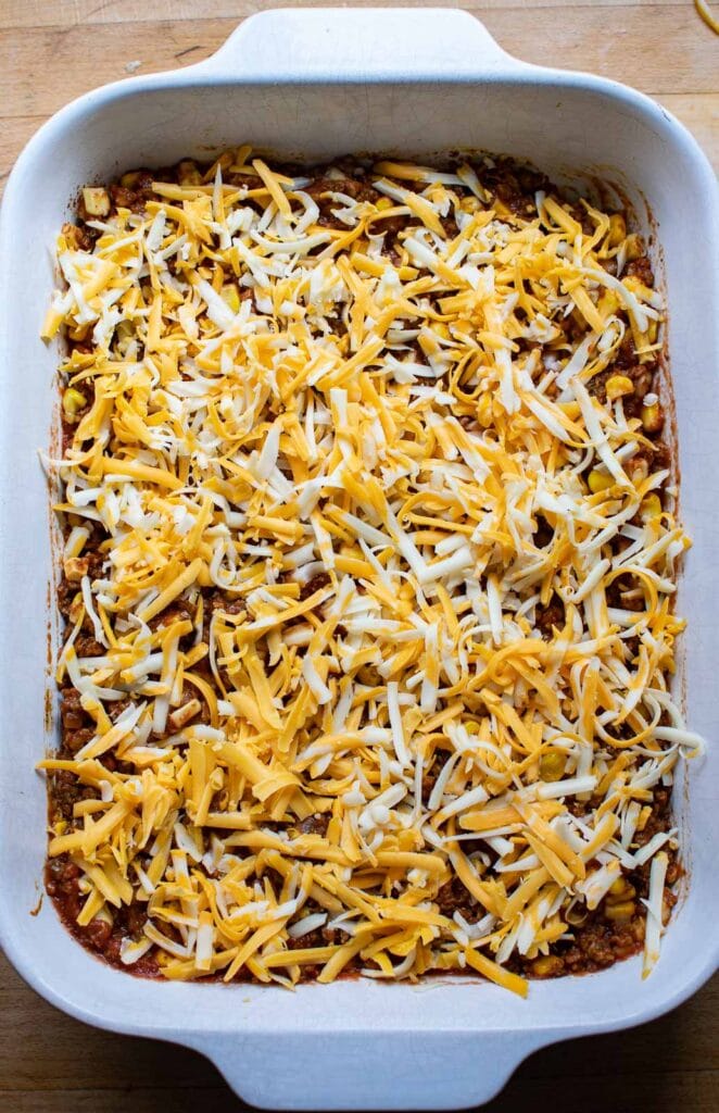 Taco Casserole mixture topped with shredded cheddar cheese.