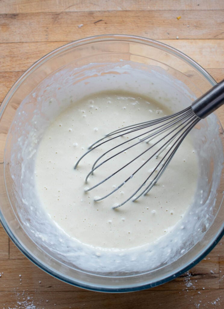 BIsquick baking mix being whisked with milk and egg.