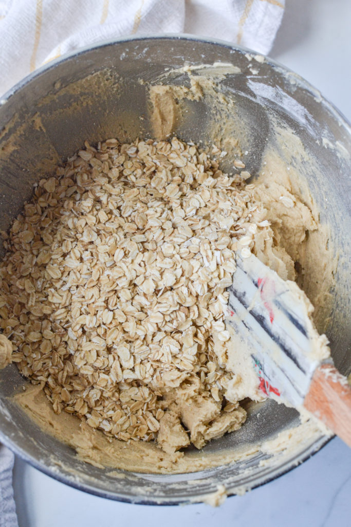 adding oats to the cookie batter