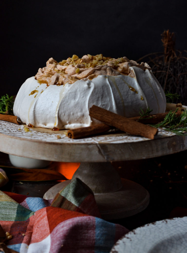 Pavlova filled with pumpkin whipped cream and sprinkled with walnuts