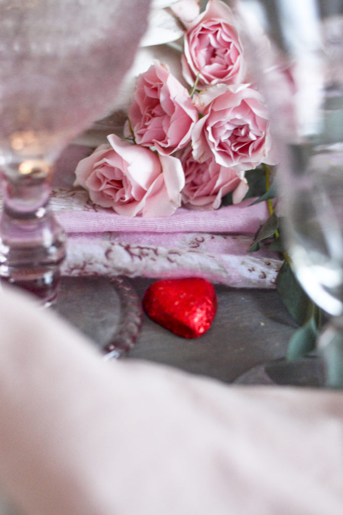 A romantic table setting for Valentine's Day in pinks, reds and gold