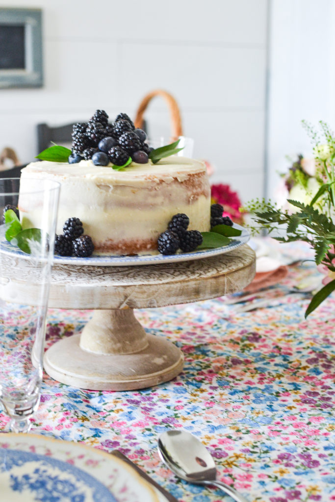 A semi naked cake decorated with fresh blueberries and blackberries