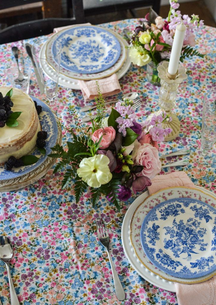 a bold floral tablecloth under mismatched floral plates