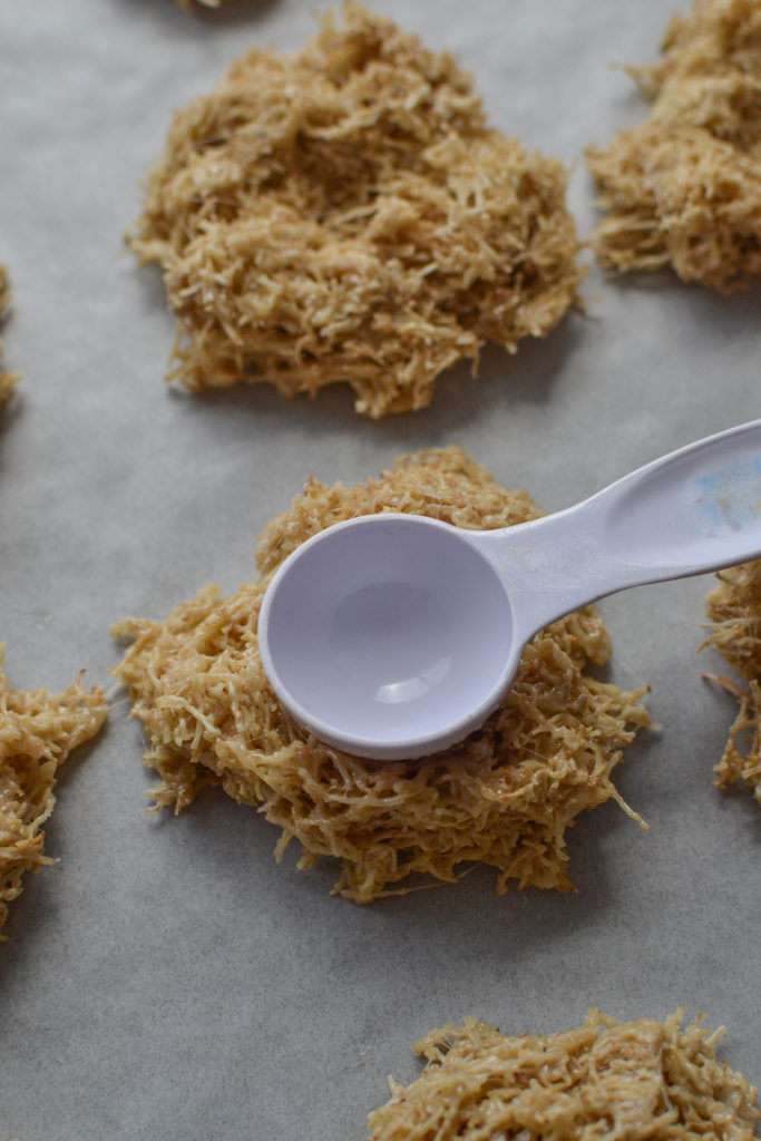 Using the back of a measuring spoon to create an indent in the nest cookies