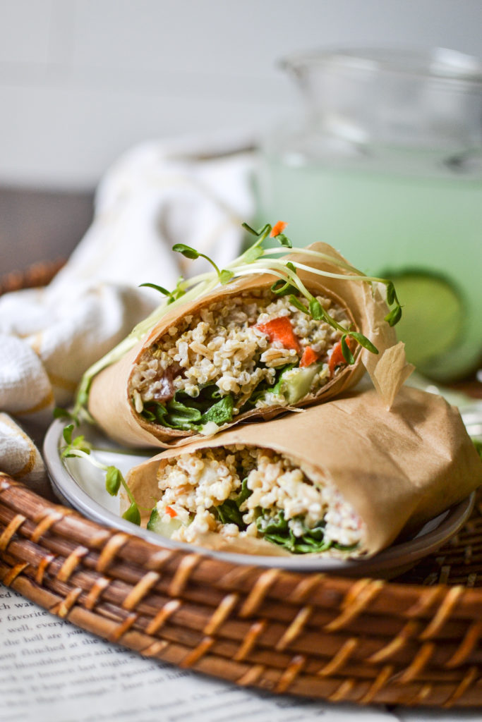 Tortilla wrap stuffed with brown rice, quinoa, lettuce, carrots and onion