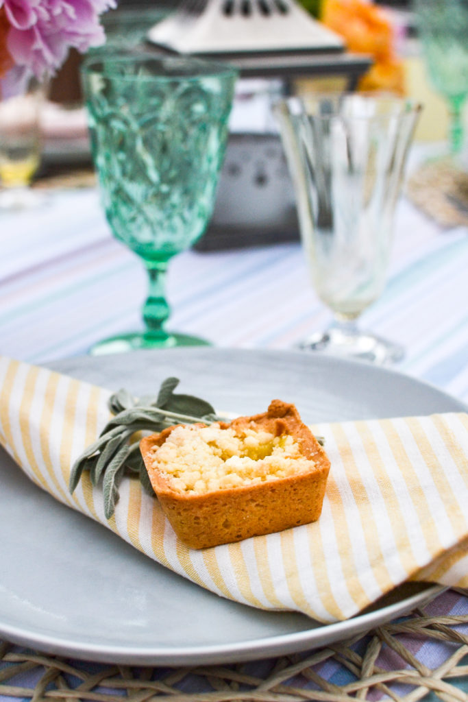 a square lemon tart on top of a yellow striped napkin