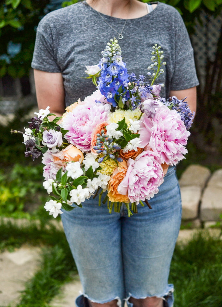 Girl posing with a garden flower hand tied bouquet
