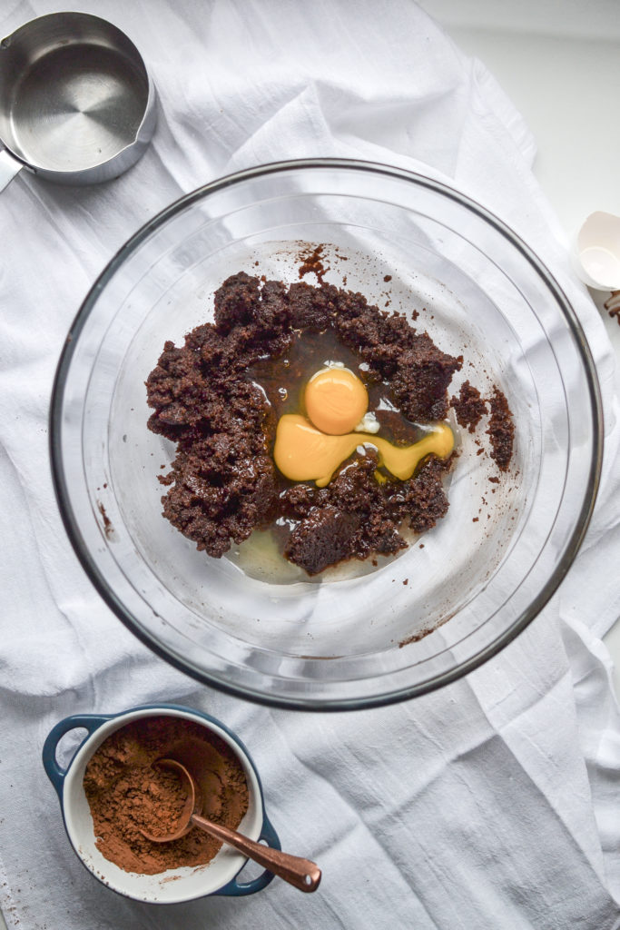 Eggs added to brownie batter in a clear glass mixing bowl