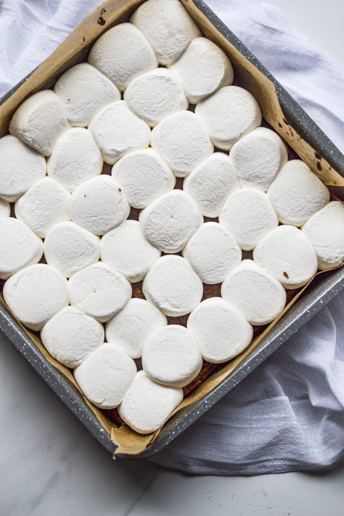 marshmallows layered on top of brownie batter before baking