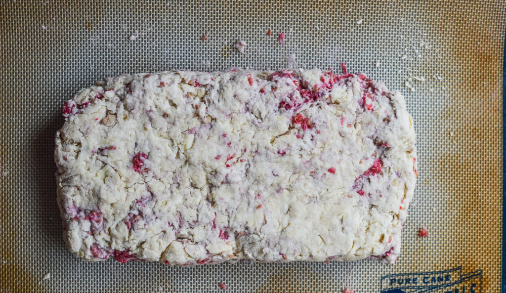 unbaked raspberry scone shaped in a loaf